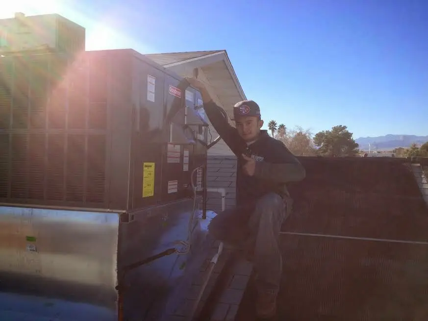 HVAC technician performing HVAC Inspection on a rooftop unit in Marblehead